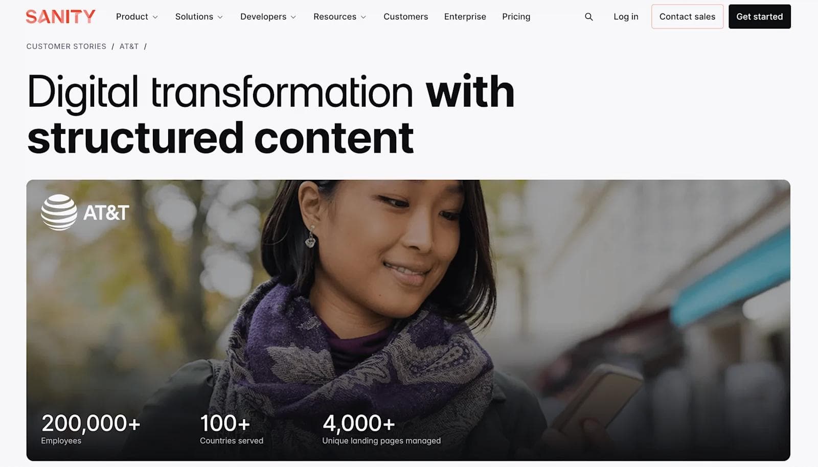 sanity case study A woman smiles while using a phone, with text about AT&T's digital transformation and structured content.